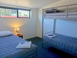 A bed or beds in a room at Hokitika's Kiwi Holiday Park and Motels