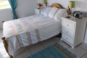 a bedroom with a bed and a night stand with a radio at Villa Benito in Nevis