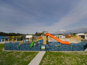 a playground with a slide in a park at Hokitika's Kiwi Holiday Park and Motels in Hokitika