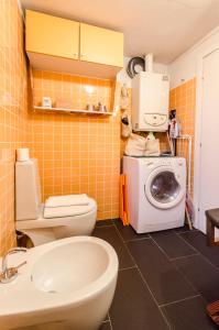 ein Badezimmer mit einem WC und einer Waschmaschine in der Unterkunft Appartamento Belle Arti, perfetto per Famiglie in Bologna