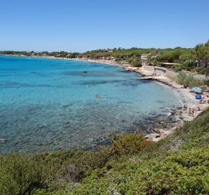 a beach with people swimming in the water at Villetta immersa nella tranquillità in Capitana