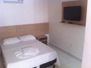 - une petite chambre avec un lit et une télévision dans l'établissement Pousada Veraneio Ponta Negra, à Natal