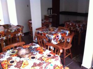 a dining room with two tables and chairs with plates on them at Pousada Veraneio Ponta Negra in Natal