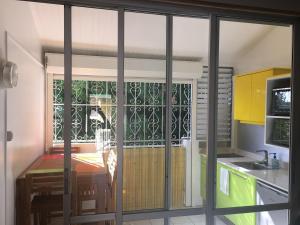 a kitchen with a table and a glass door at Studio-Mezzanine proche toutes commodités in Le Gosier