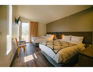 Habitación de hotel con 2 camas y ventana en Terra Nova Cabins, en West Yellowstone