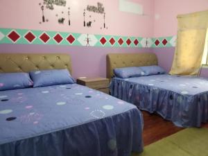 2 camas en una habitación con sábanas azules y moradas en Fu Ya N B&B, en Lanyu