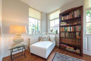 a living room with a chair and a book shelf with books at Vakantiehuis Villa 63 in Heel