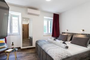 ein Schlafzimmer mit großem Bett und ein Badezimmer in der Unterkunft Apinelo Port Rooms in Split