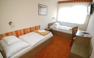 um quarto com 2 camas, uma secretária e uma janela em Hotel Bavaria em Abda