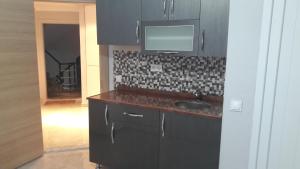 a kitchen with a sink and a tv on the wall at Gunay Pansiyon Antalya in Antalya