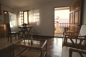 a living room with a table and chairs and a balcony at Casa Los Jazmines in Sucre