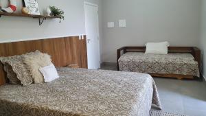 1 dormitorio con 2 camas y almohadas en Residencial Vila das Canoas, en Bombinhas