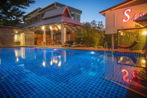 uma piscina em frente a um hotel à noite em S48 Hotel em Chiang Mai