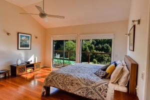 a bedroom with a bed and a large window at Afterglow Cottages in Bellingen