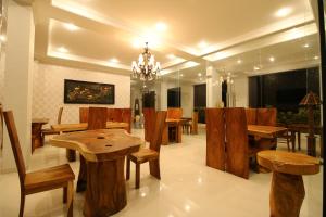 een eetkamer met houten tafels en stoelen bij Wahyu Dana Hotel in Lovina
