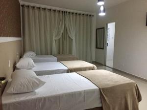 Giường trong phòng chung tại Hotel Guarulhos