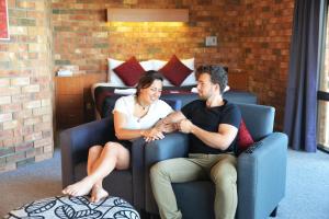 
a man and a woman sitting on a couch at Kangaroo Island Seaside Inn in Kingscote
