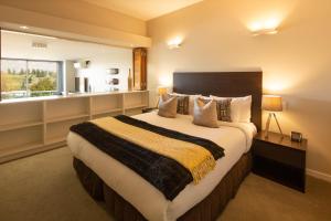 Un dormitorio con una cama grande y una ventana en QS Jade, en Queenstown