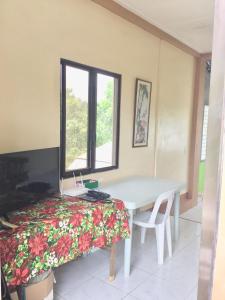 una camera con tavolo, letto e finestra di Larosa Hostel Bed and Breakfast a Città di Puerto Princesa