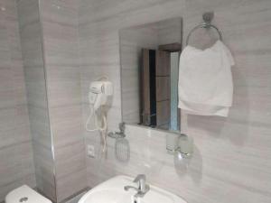 Baño blanco con lavabo y espejo en Happy House, en Samarkand