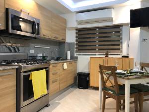 a kitchen with a stove and a table with a yellow towel at Estancia Riviera Colonial I in Santo Domingo