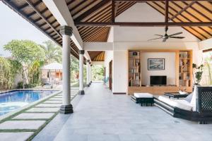 an outdoor living area with a pool and a house at Villa Lotus in Nusa Lembongan