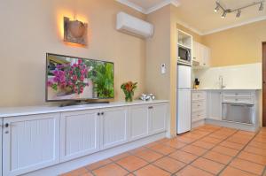 a kitchen with a white counter top and white walls at Villa San Michele (Official) in Port Douglas