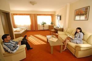 un hombre y una mujer sentados en una sala de estar en Hotel Bavaria, en Abda