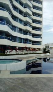 un gran edificio de apartamentos con piscina frente a él en Dpto Moderno Frente al Mar. Edf: Deymar 7mo Piso, en Tonsupa