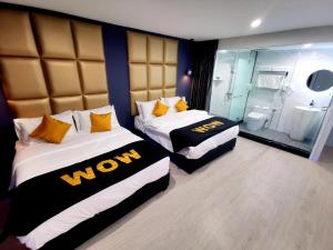 2 łóżka w pokoju hotelowym z łazienką w obiekcie WOW Hotel Penang w mieście George Town