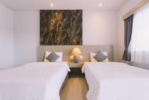 卡塔海灘的住宿－幻想山簡易別墅酒店，墙上画画的房间里设有两张床