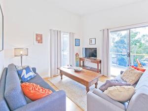 a living room with two blue couches and a coffee table at Hahndorf Haven-Central Hahndorf in Hahndorf