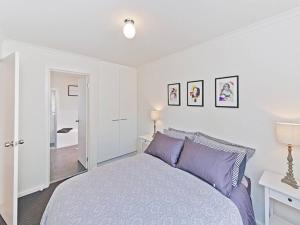 漢道夫的住宿－Hahndorf Haven-Central Hahndorf，一间卧室配有一张带紫色枕头的大床