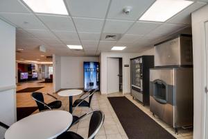 a room with two tables and chairs and a refrigerator at Studio 6-Brownsville, TX in Brownsville