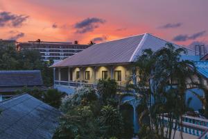 a house with a roof with a sunset in the background at Fantasy Hill Bungalow in Kata Beach