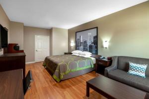 Habitación de hotel con cama y sofá en Super 8 by Wyndham Houston Northwest Cypress en Cypress