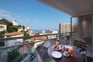 un tavolo con piatti di cibo su un balcone di Monaco, sea view, bright studio a Beausoleil