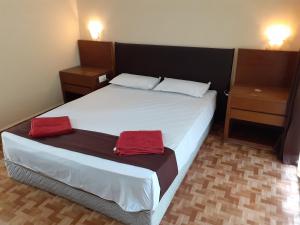 a bedroom with a bed with two red towels on it at Country View Cottage Colva in Colva