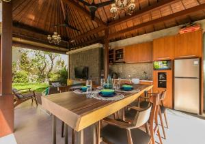 eine Küche mit einem großen Holztisch mit Stühlen in der Unterkunft Villa Niketan Sanur - Three bedroom, Sanur, Near Icon Mall, Harbor in Sanur