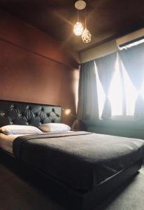 a bedroom with a bed and a window at Borneo Sweet Guesthouse in Kuching