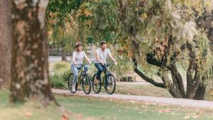 un hombre y una mujer montando bicicletas en un parque en Country Club Villas, en Launceston