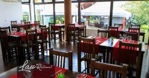 a restaurant with tables and chairs with red tablecloths at Pensiunea Oficial in Prejmer