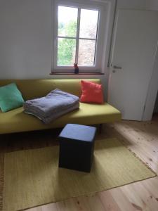 um sofá verde com almofadas coloridas sentadas num quarto em Ferienhaus am Schloss, Haag 127 em Aufsess