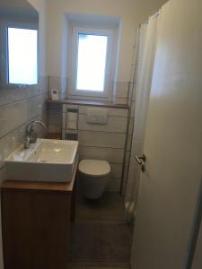 ein Bad mit einem Waschbecken, einem WC und einem Fenster in der Unterkunft Ferienhaus am Schloss, Haag 127 in Aufseß