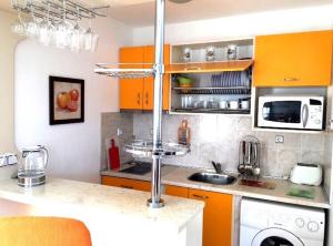 スヴェティ・ヴラスにあるDuplex apartmentsのキッチン(オレンジ色のキャビネット、カウンタートップ付)