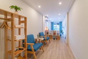 ハノイにあるGraffiti Hotelの木製の棚と青い椅子が備わる部屋