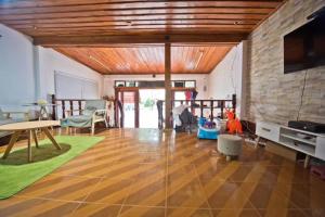 a living room with a wooden ceiling and a tv at Phousi Guesthouse 2 in Luang Prabang