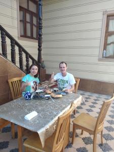 un hombre y una mujer sentados en una mesa en ZARIN Guest House B&B, en Bukhara