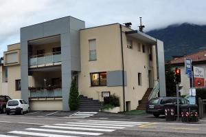 un edificio en una calle con coches aparcados delante en B&B Maya, en Merano