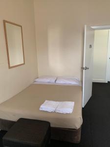 a bedroom with a bed and a dresser at National Hotel Toowoomba in Toowoomba